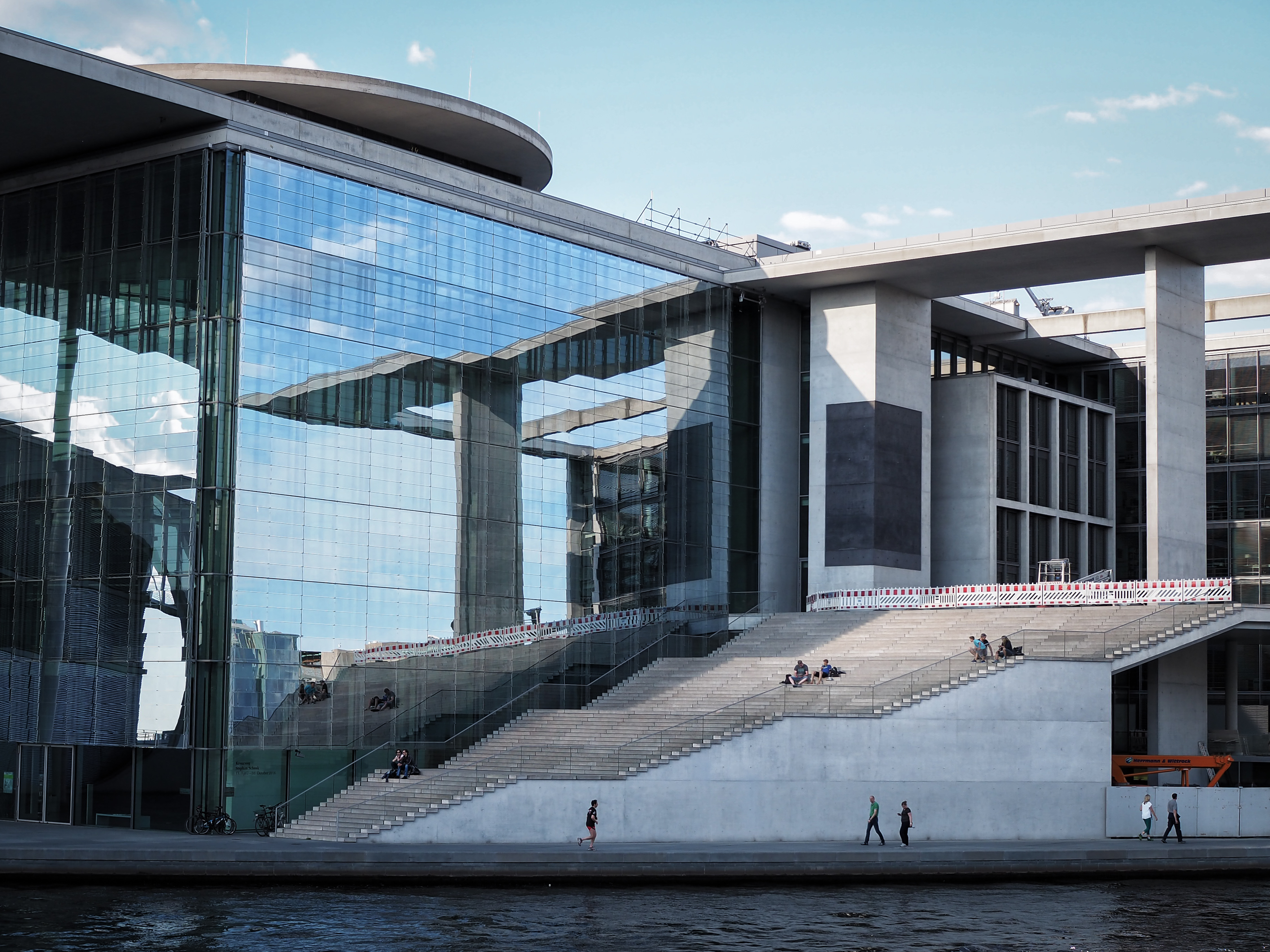 Das Foto zeigt einen Teil eines Gebäudes im Regierungsviertel. Zu sehen ist eine gläserne Fassade und eine hohe Treppe.
